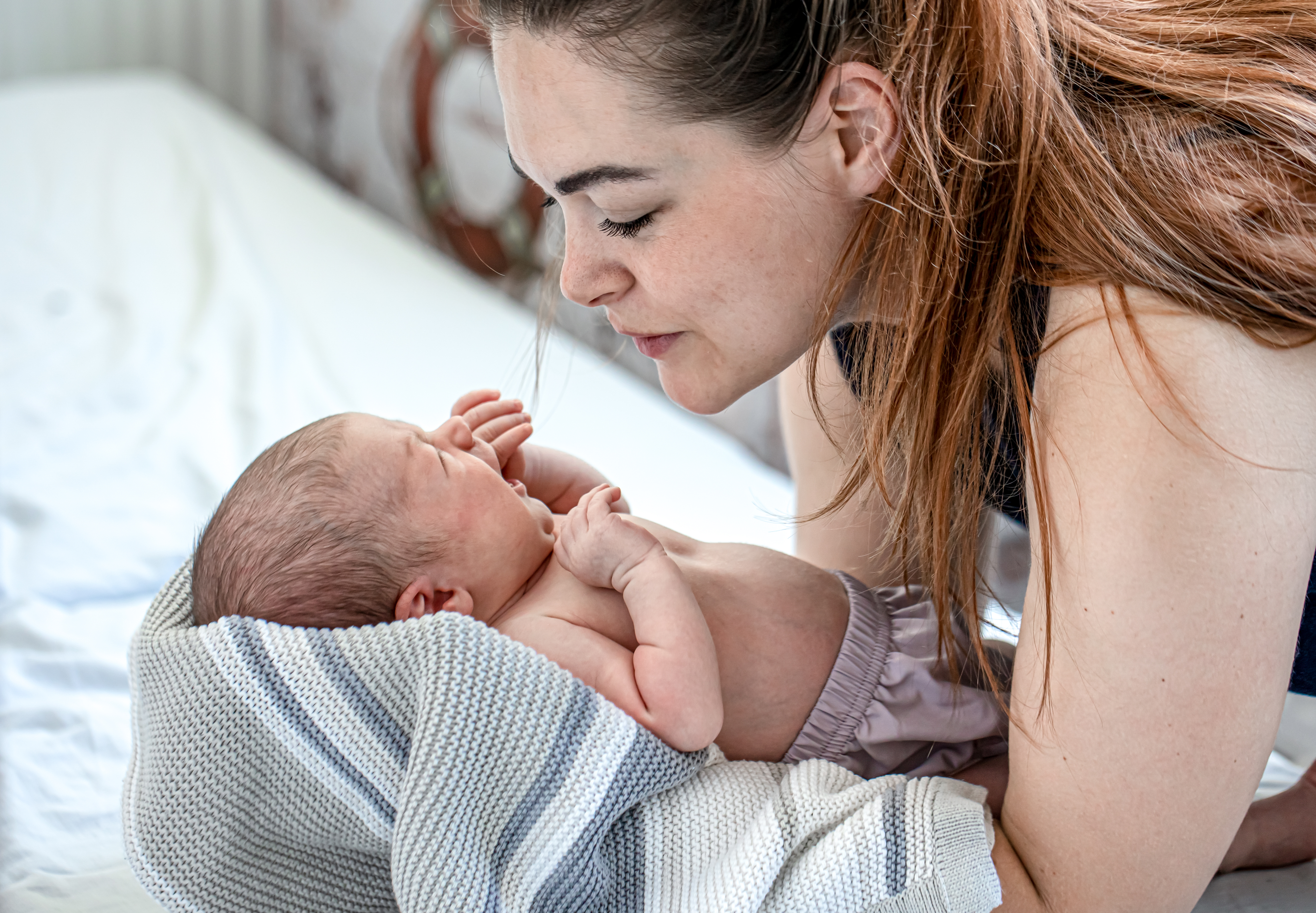 newborn-toddler-cries-into-mother-s-arms-bedroom.jpg